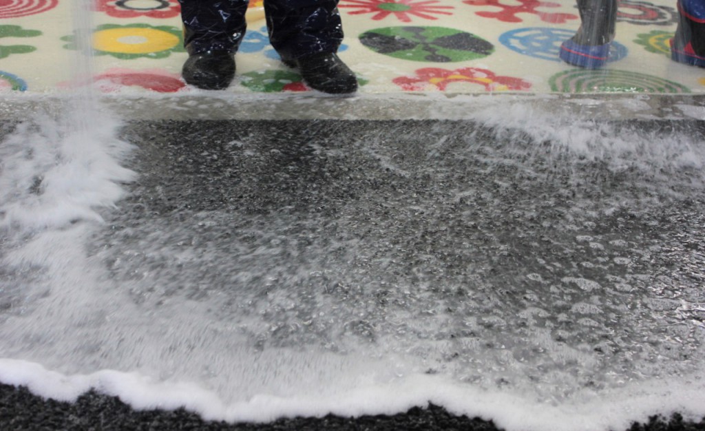 絨毯(ラグ)に大量の水をかけて洗う