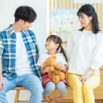 ぬいぐるみを抱く子供と家族