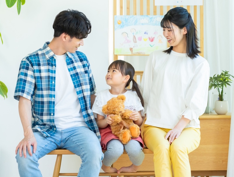 ぬいぐるみを抱く子供と家族