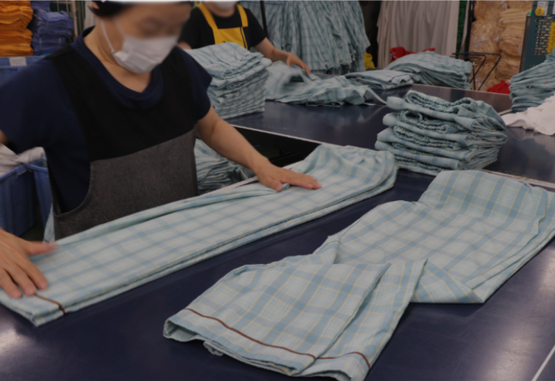 大量の品物を仕分け・たたむクリーニング作業の様子