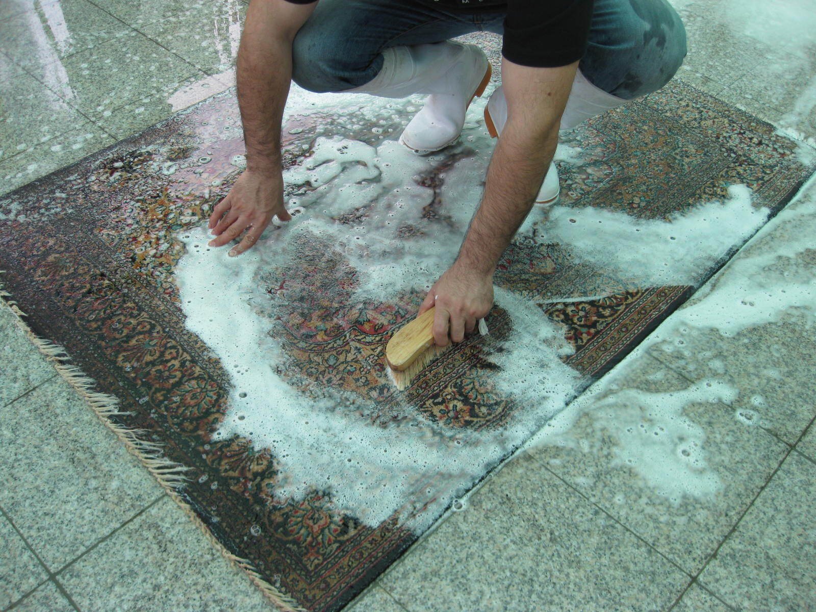 泡を使って絨毯を手で洗う工房の作業。織りや素材に合わせて扱います。