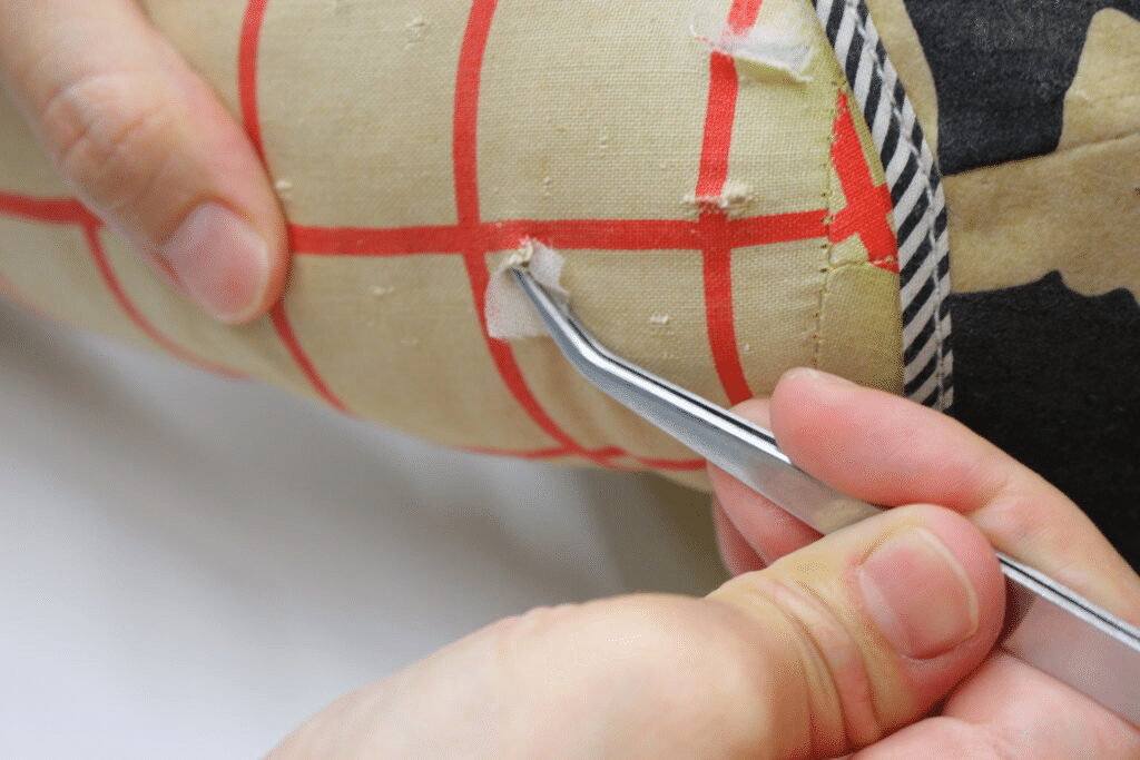 ピンセットを使って、細かな箇所へ補強材を扱う作業。