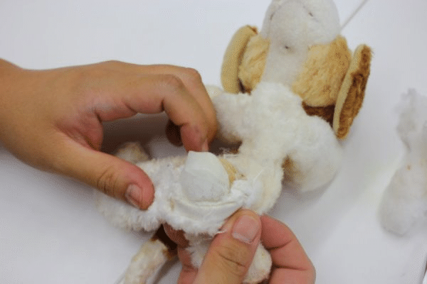 縫い目を開き、内部の中綿を取り出す作業。