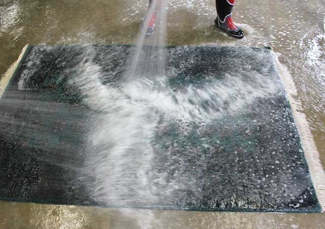 水をかけてすすぐ丸洗いの工程。汚れを含んだ洗浄液を流していきます。
