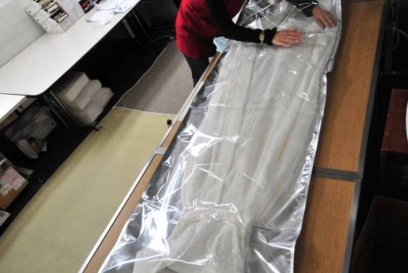 長期保存加工の作業例。着用予定や付属品に合わせて保管方法を相談します。