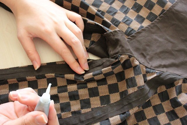 テープと生地の境目へ、接着の処理を少しずつ行っている作業例。