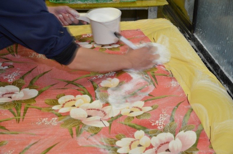 花柄の布団を広げて泡で手洗いする工程。