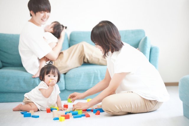 家族がソファのある部屋で過ごすイメージ。