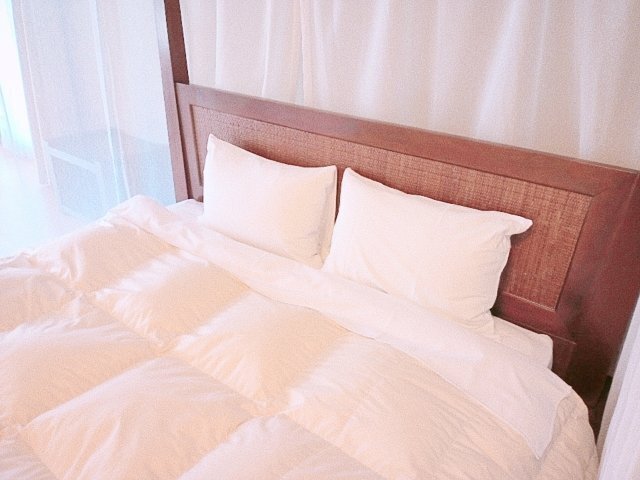 白い寝具を整えたベッドのイメージ。個別事例の施工後写真ではありません。