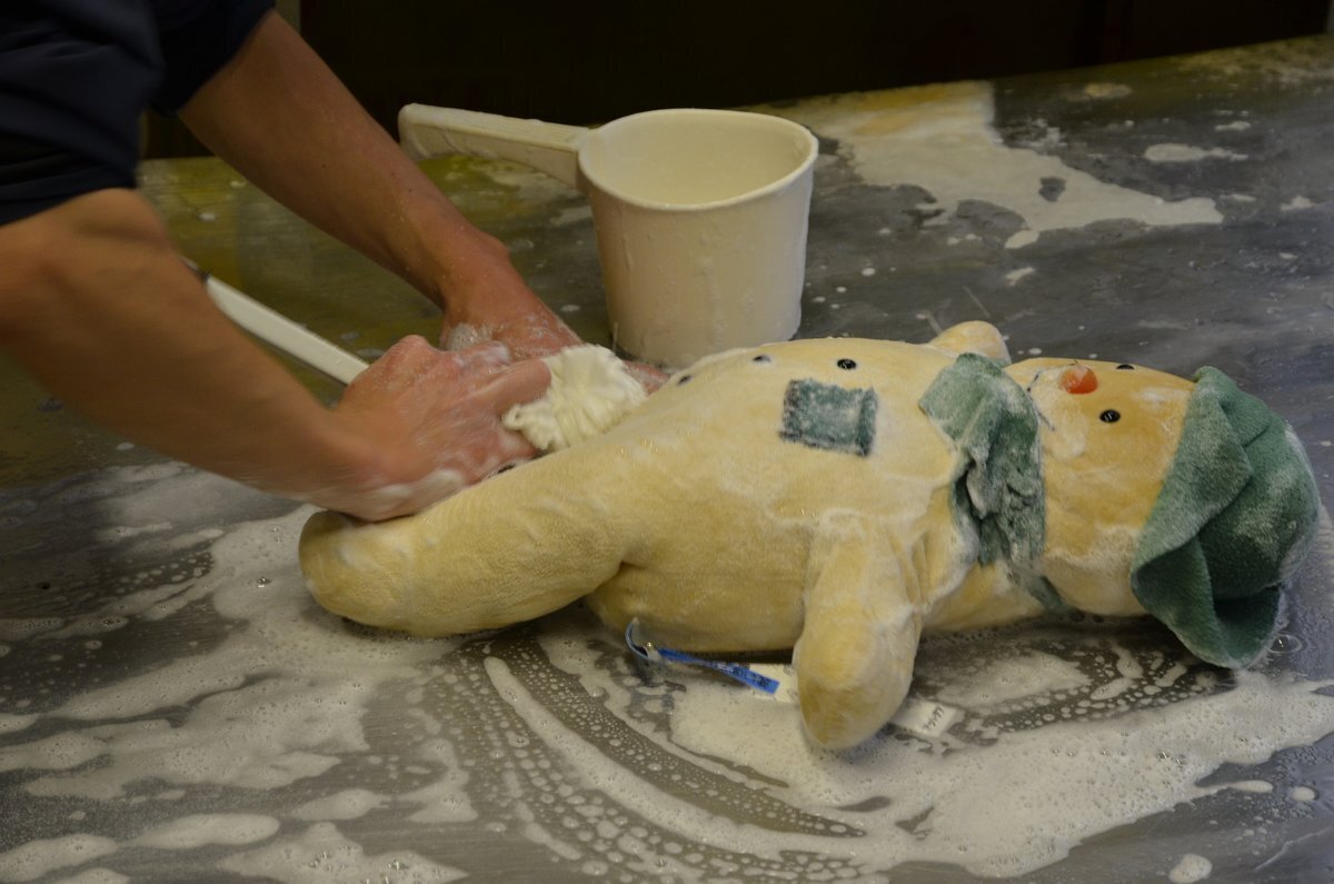 ぬいぐるみを泡と水で手洗いする作業例。