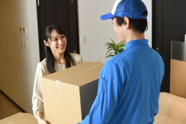 玄関先で荷物を受け渡す宅配のイメージ。