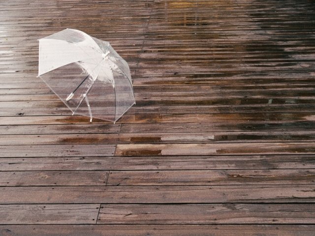 雨にぬれた床と傘のイメージ。