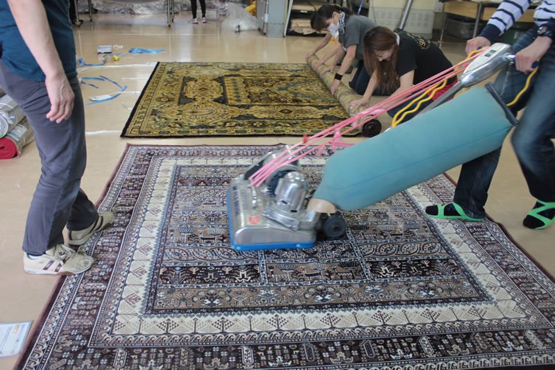 乾燥後の絨毯に、掃除機やブラシを使って仕上げ・点検する作業。