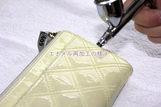 エナメル再加工で、財布の表面へ吹き付ける作業。